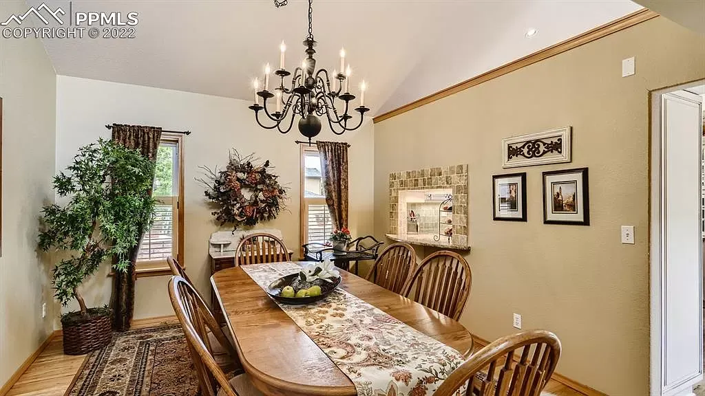 A dining room with a table and chairs and a chandelier.