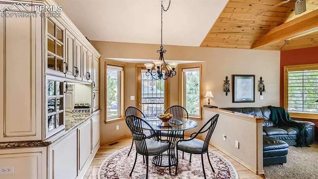 A dining room with a table and chairs and a chandelier.