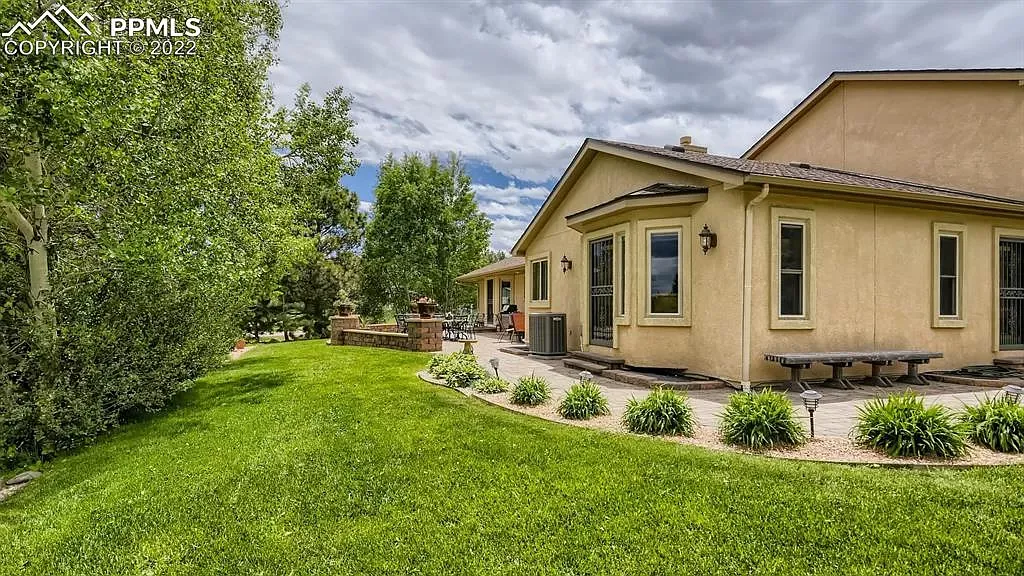 A large house with a lot of windows and a large lawn in front of it.