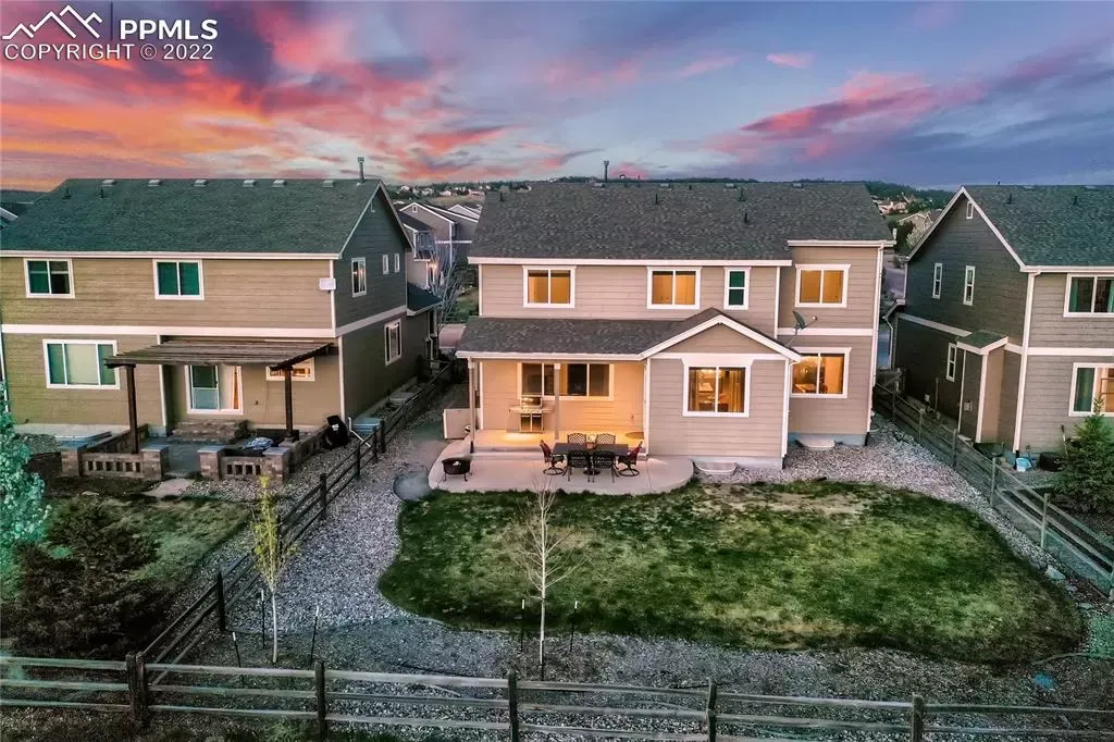 An aerial view of a house with a fence in front of it.