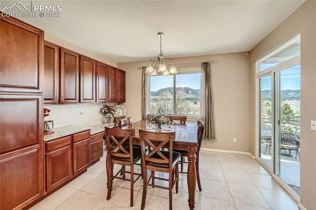 A dining room with a table and chairs and a large window.