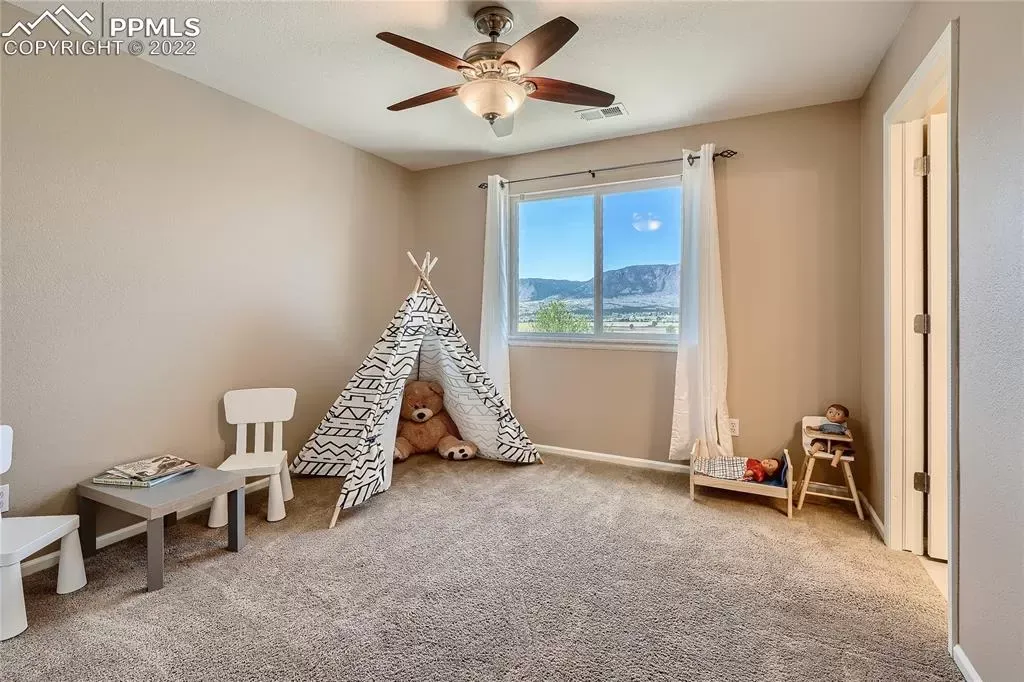 A bedroom with a teepee and a ceiling fan