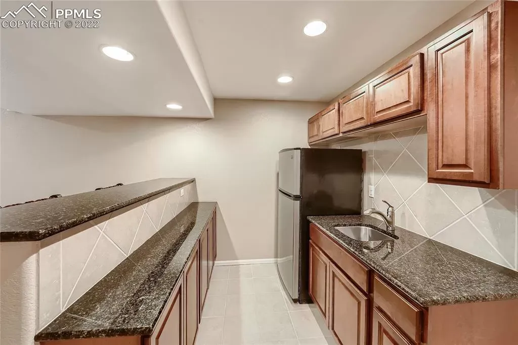 A kitchen with granite counter tops and wooden cabinets