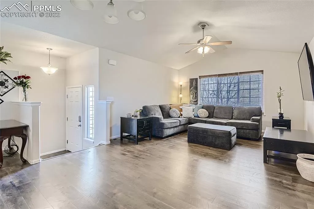 A living room filled with furniture and a ceiling fan.