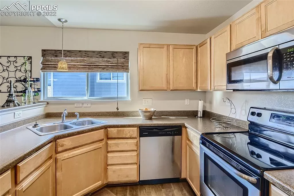 A kitchen with stainless steel appliances and wooden cabinets.