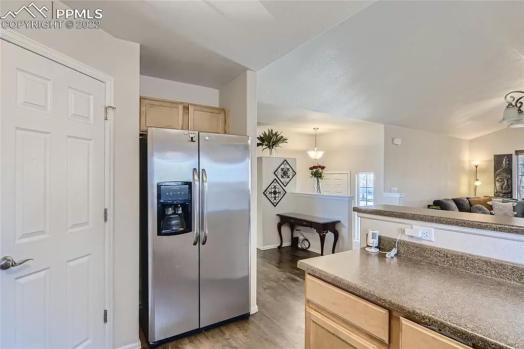 A kitchen with a stainless steel refrigerator and a granite counter top.
