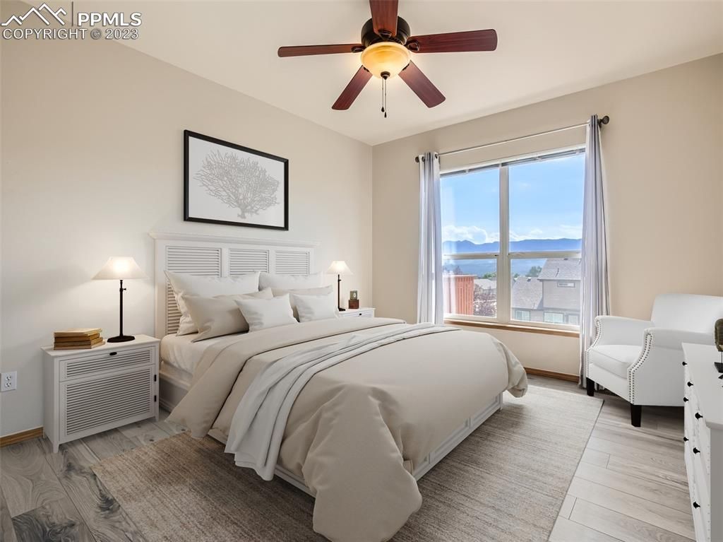 A bedroom with a large bed and a ceiling fan