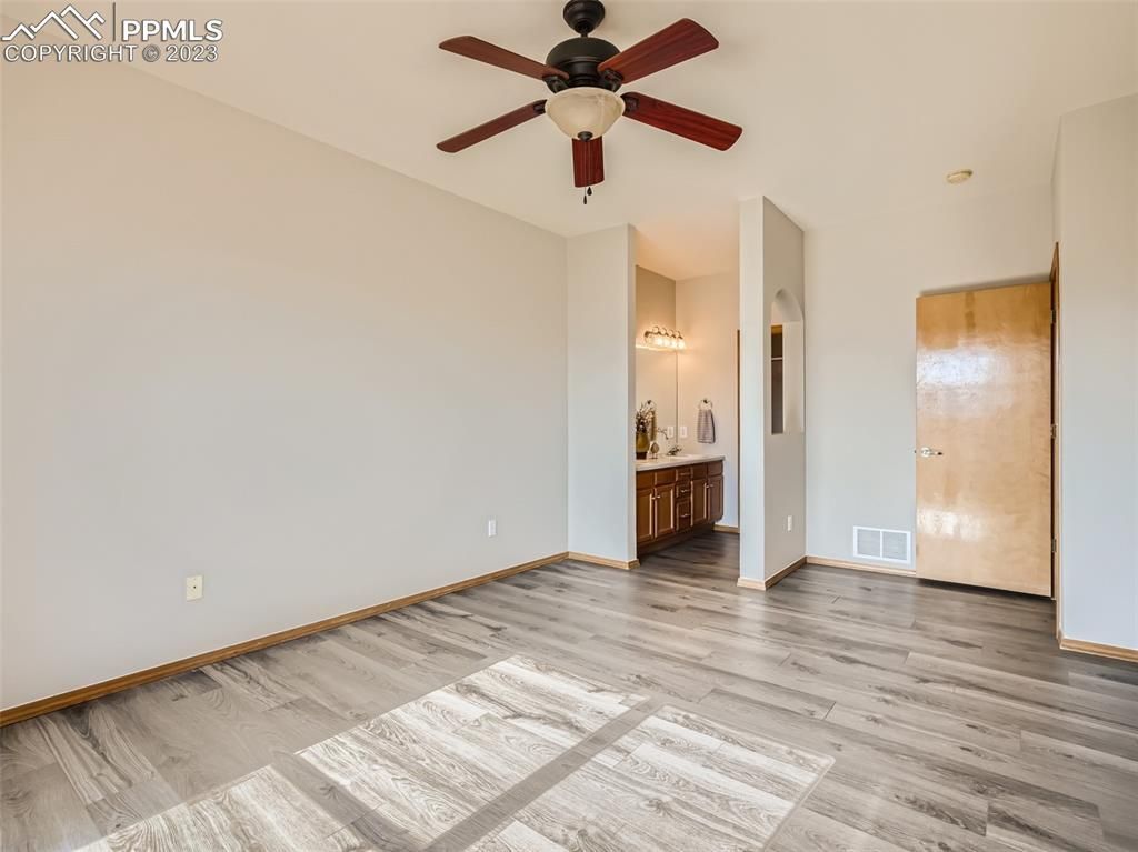 A living room with hardwood floors and a ceiling fan