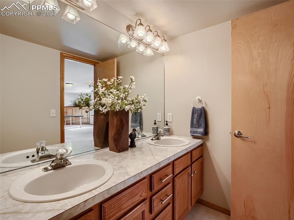 A bathroom with two sinks and a large mirror.