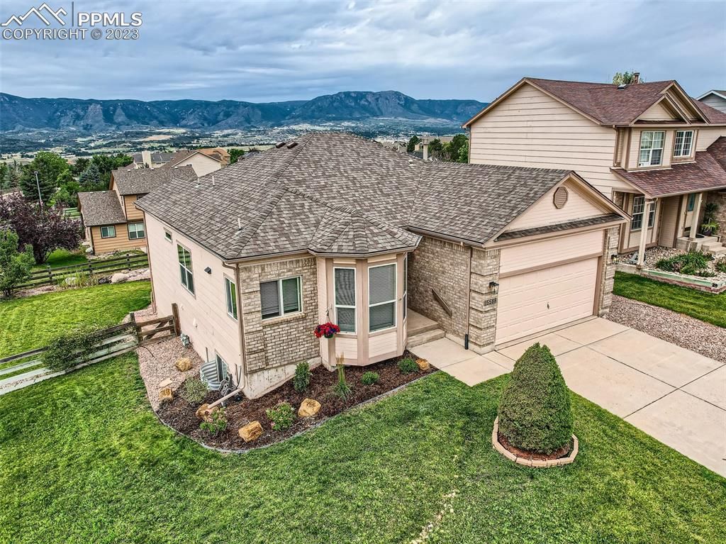 An aerial view of a house with a view of mountains in the background.