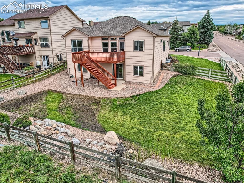 An aerial view of a large house with a fence in front of it.