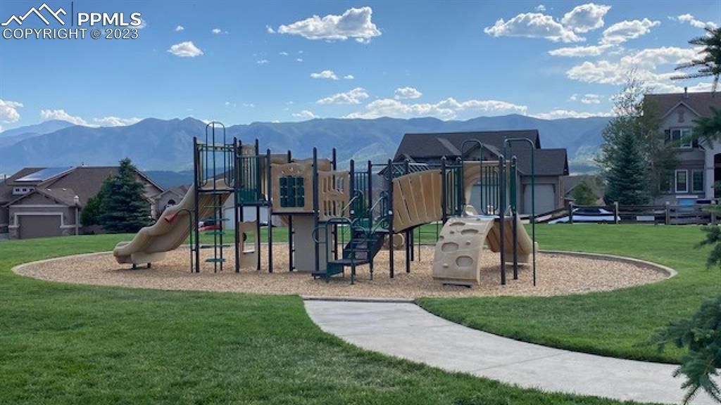 A playground in a park with mountains in the background.