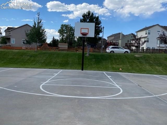 A basketball court with a car parked in the background
