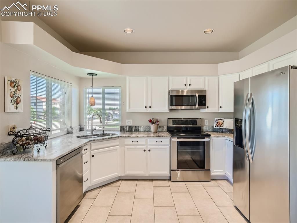 A kitchen with white cabinets and stainless steel appliances.