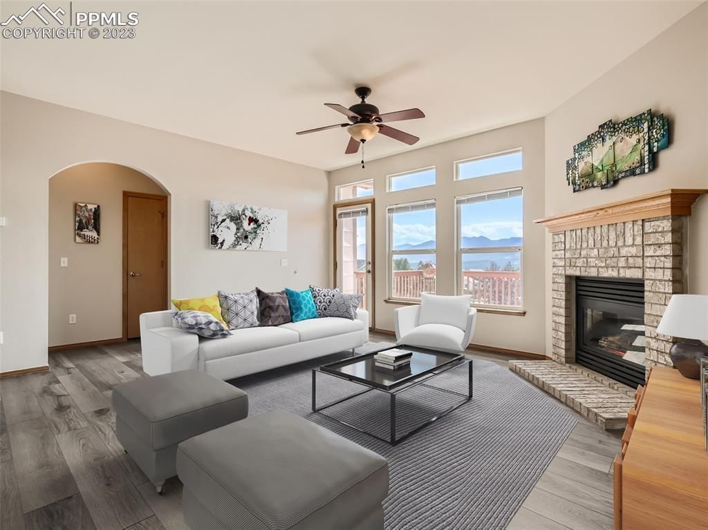 A living room with a fireplace and a ceiling fan