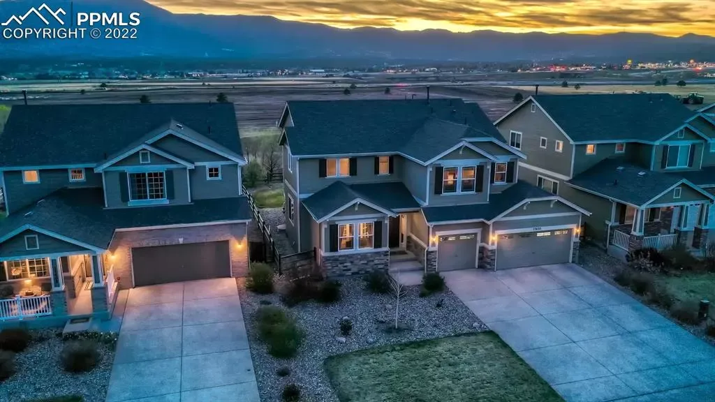 An aerial view of a row of houses with a sunset in the background.