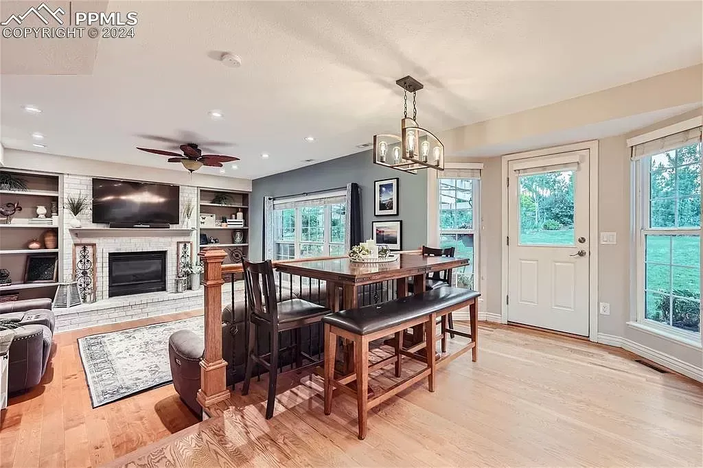 A living room with a table and chairs and a fireplace.