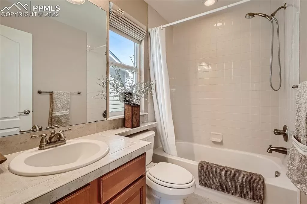 A bathroom with a sink , toilet , tub and mirror.