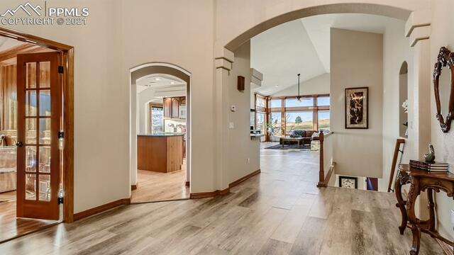 A hallway in a house with hardwood floors and a table.