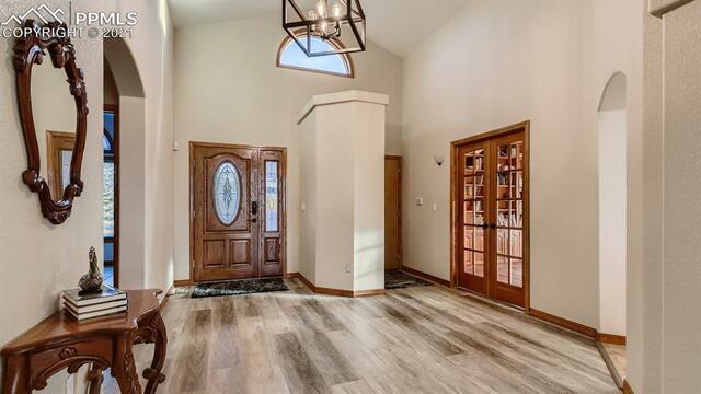 A hallway in a house with hardwood floors and a mirror.