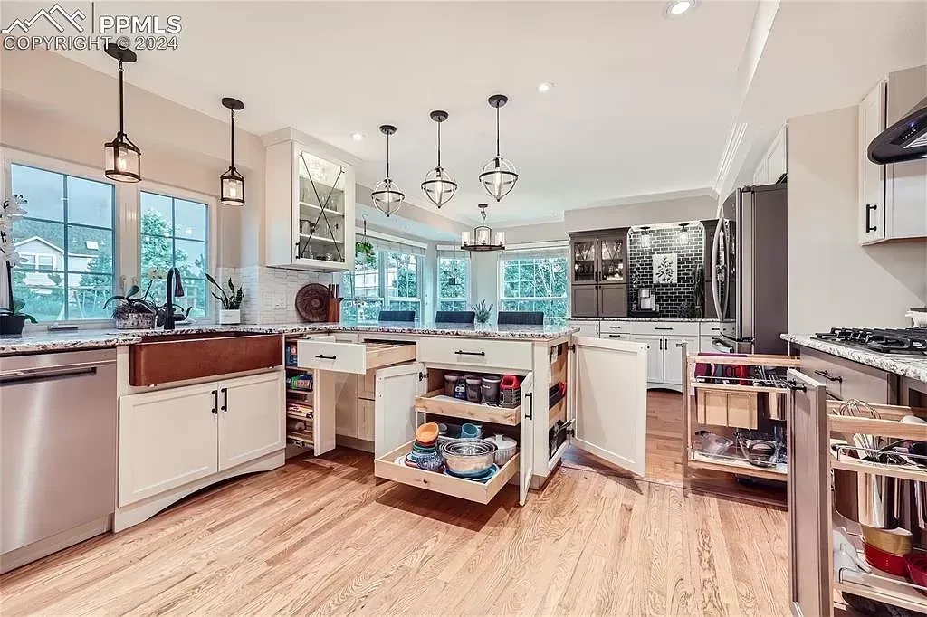 A large kitchen with stainless steel appliances and wooden floors.