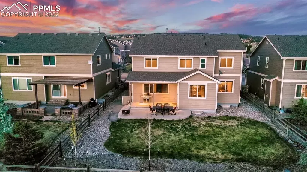 An aerial view of a row of houses with a large backyard.
