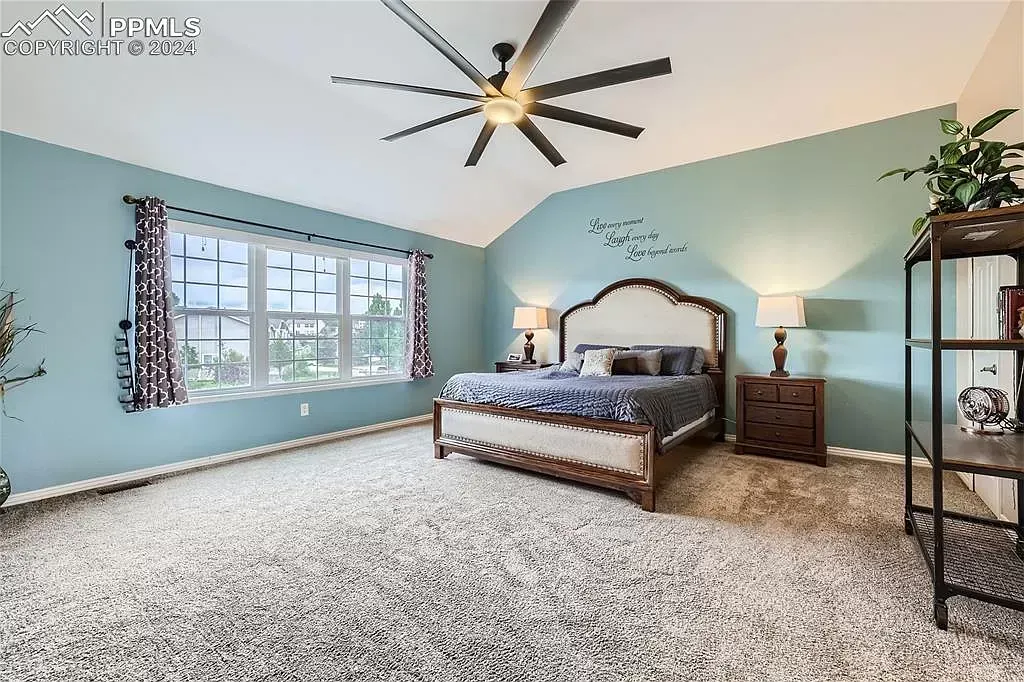 A bedroom with a large bed and a ceiling fan