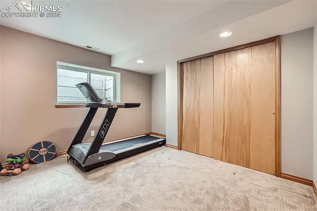 There is a treadmill in the corner of the room.