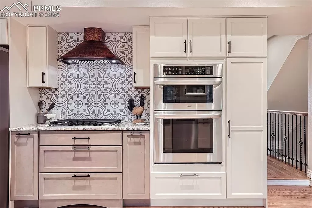 A kitchen with white cabinets and stainless steel appliances.