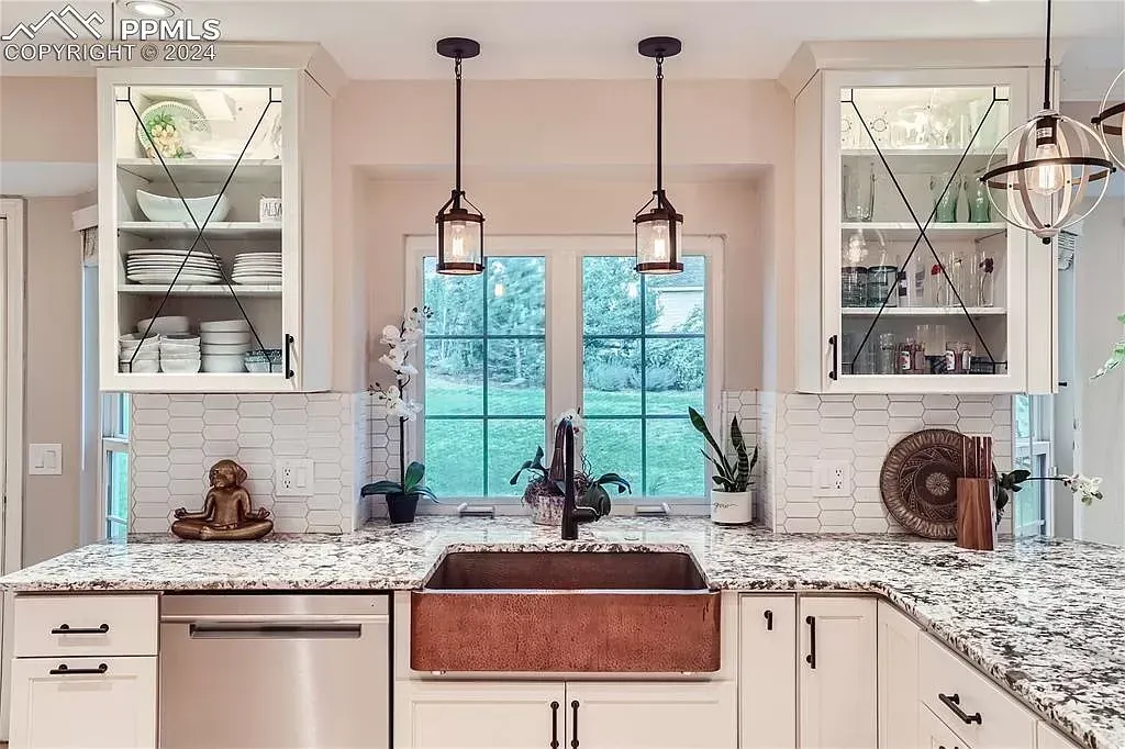A kitchen with a copper sink and granite counter tops.