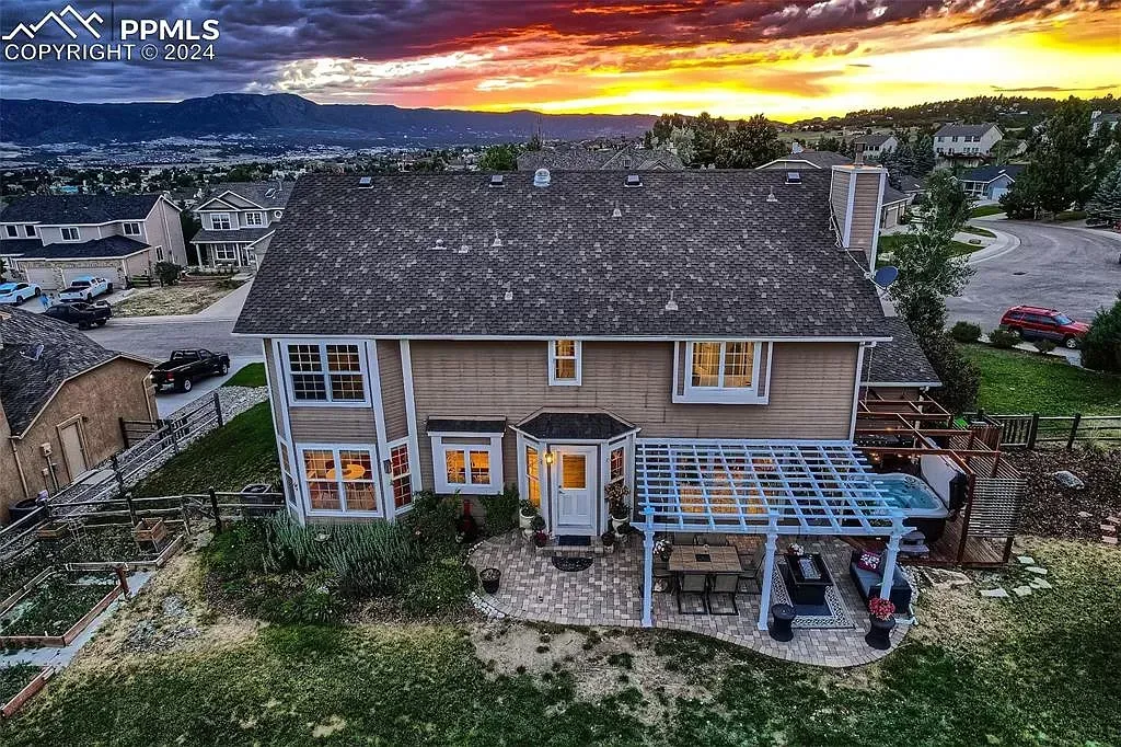 An aerial view of a house with a sunset in the background.