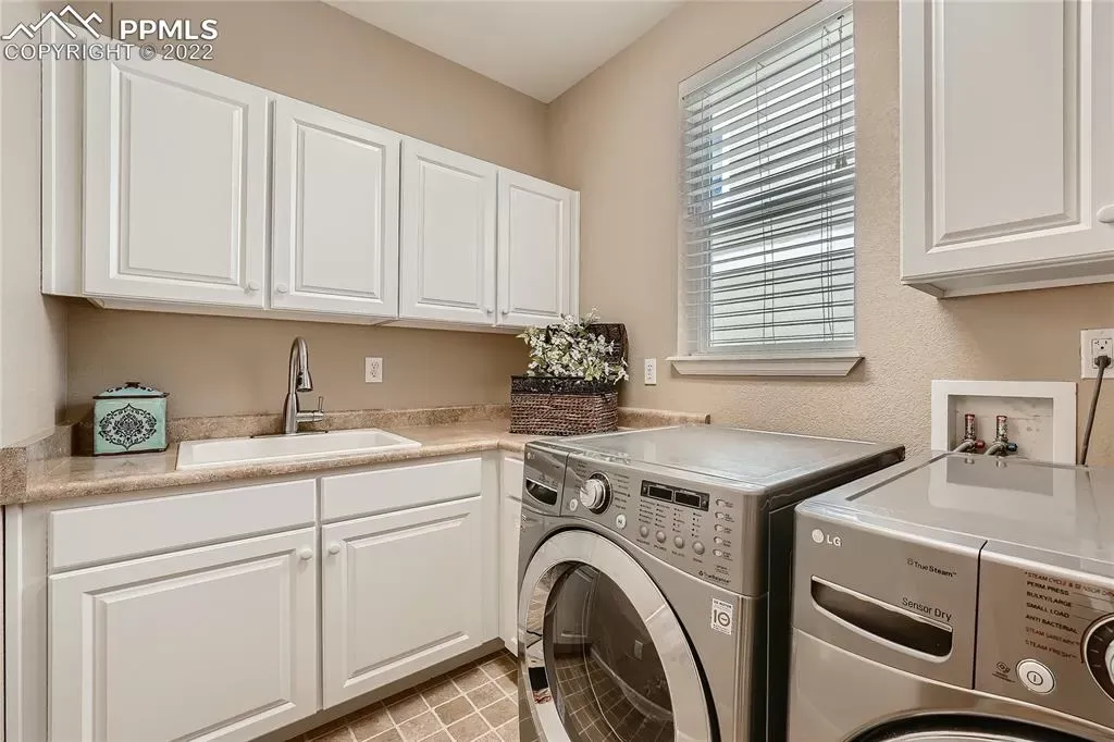 A laundry room with a washer and dryer and a sink.