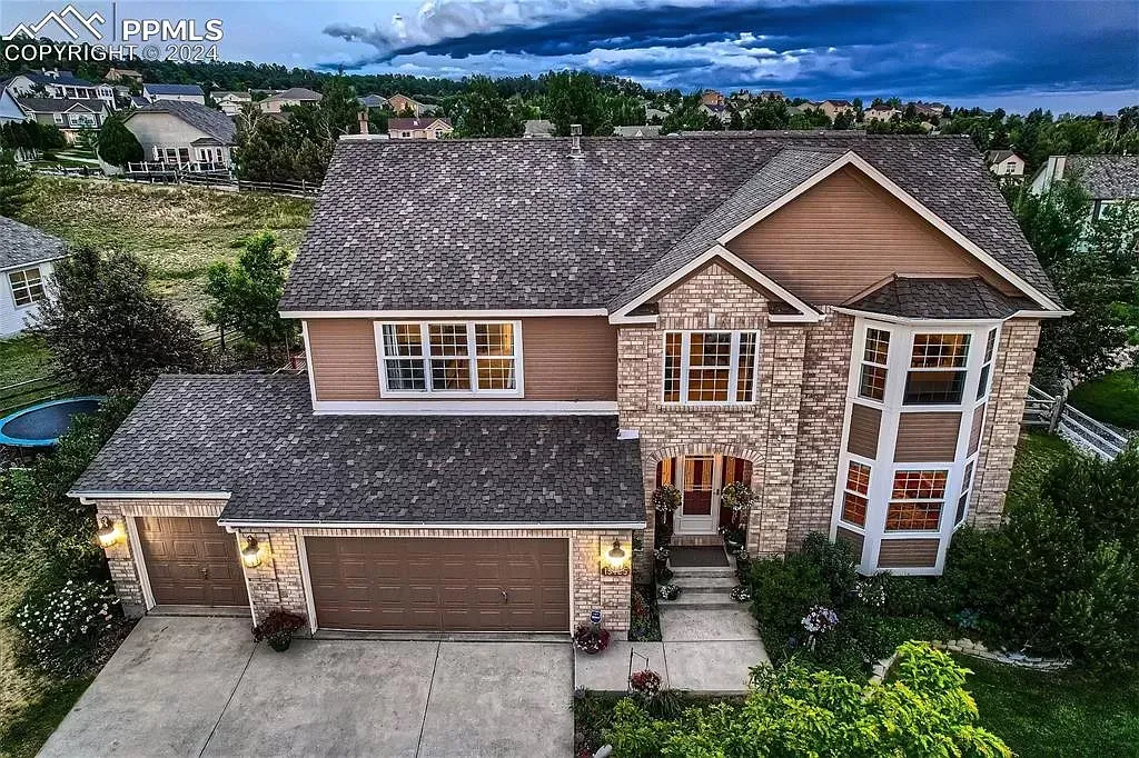 An aerial view of a large house with a gray roof