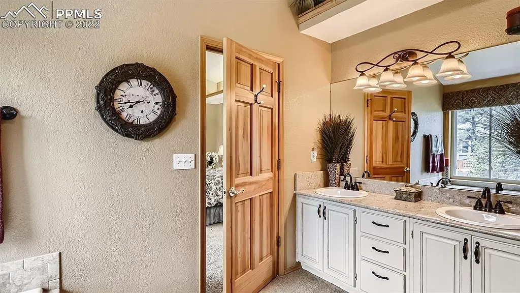 A bathroom with two sinks and a clock on the wall.