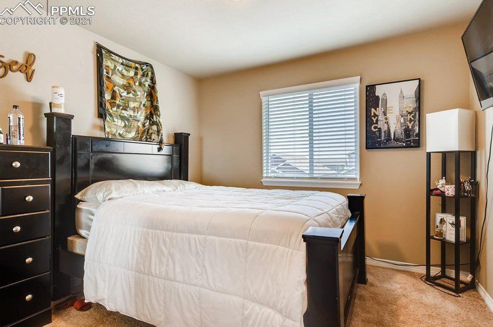 A bedroom with a bed , dresser , and television.