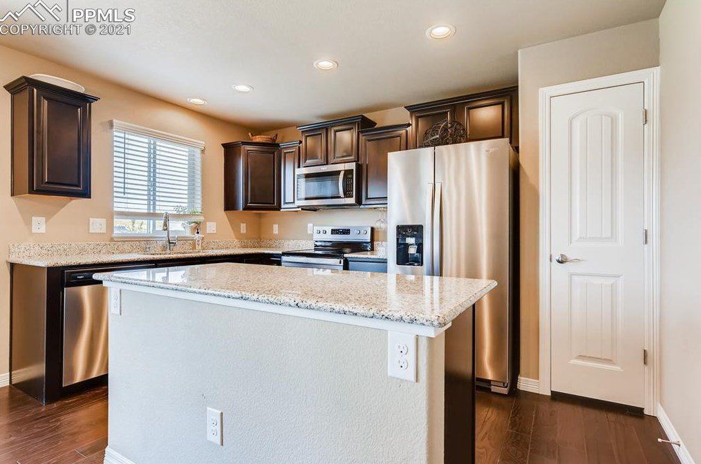 A kitchen with stainless steel appliances and granite counter tops.