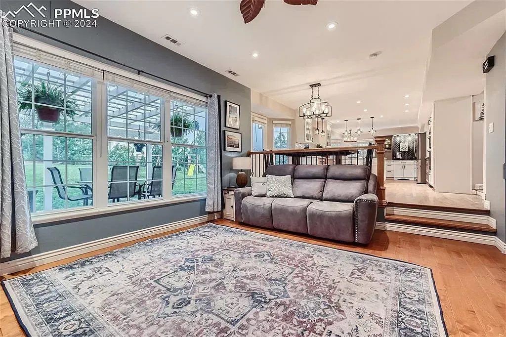 A living room with a couch , rug , and windows.
