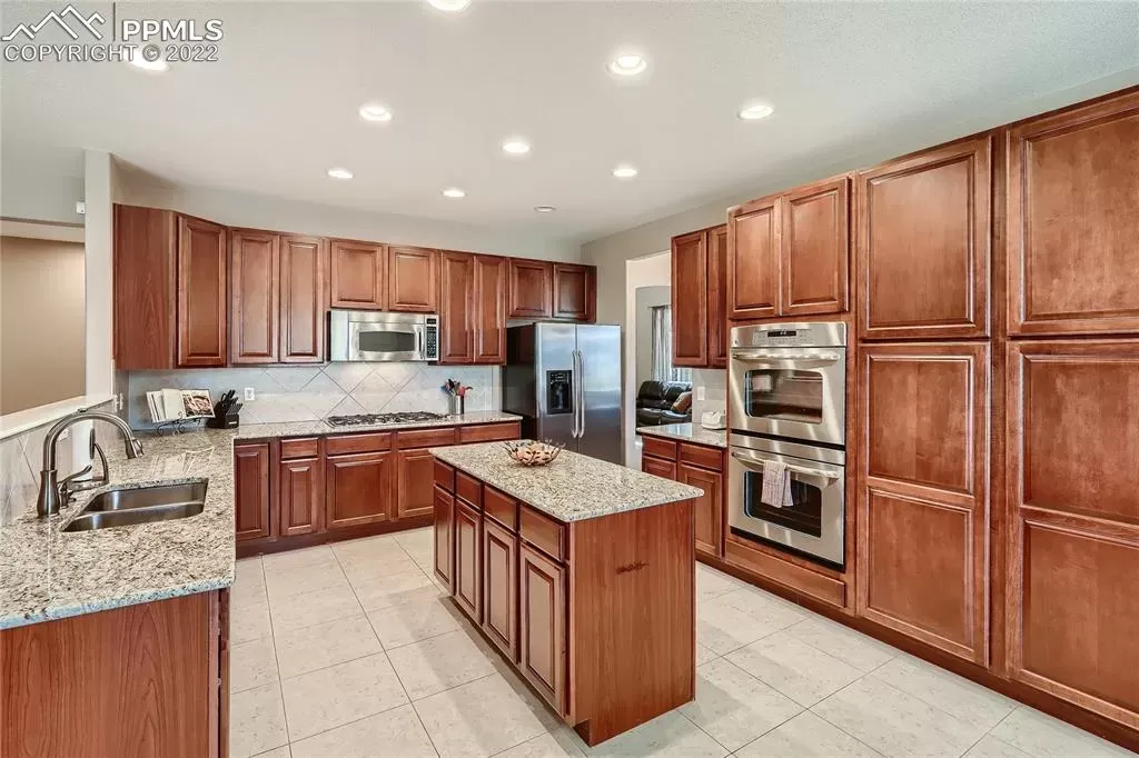 A large kitchen with wooden cabinets and granite counter tops