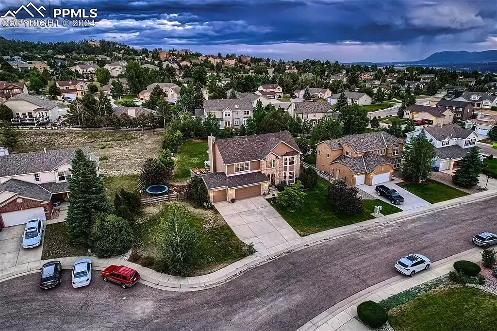 An aerial view of a residential area with cars parked on the side of the road.