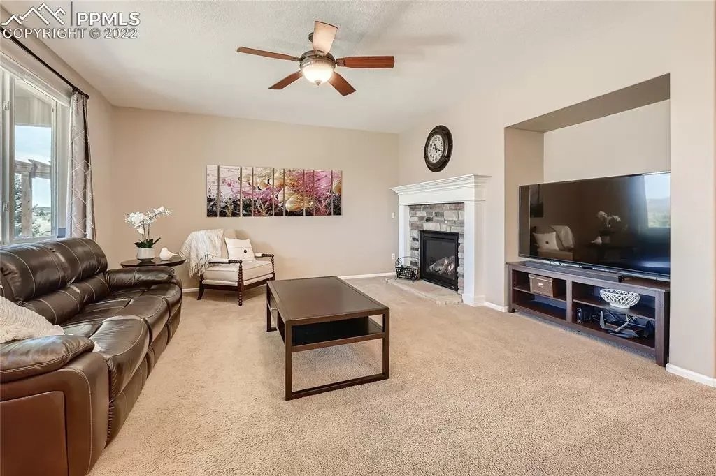 A living room with a couch , coffee table , television and fireplace.