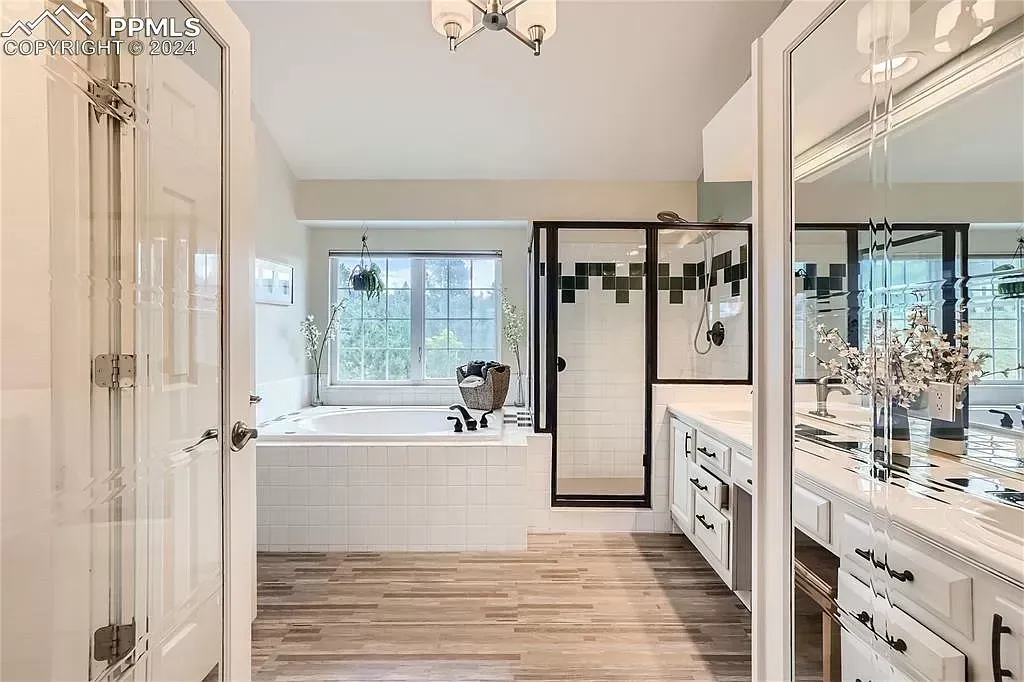 A bathroom with a large tub and a walk in shower.