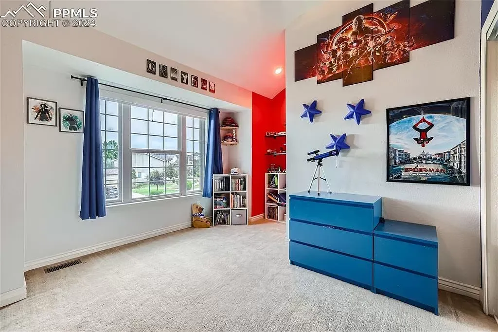 A bedroom with a blue dresser and a large window