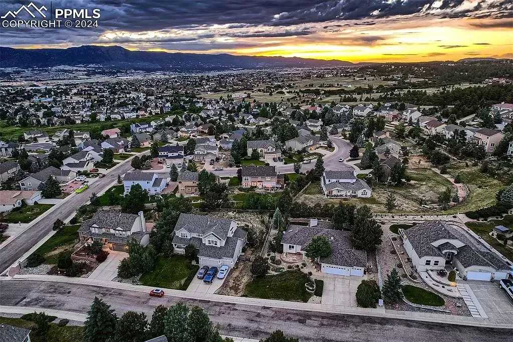An aerial view of a residential area with a sunset in the background.