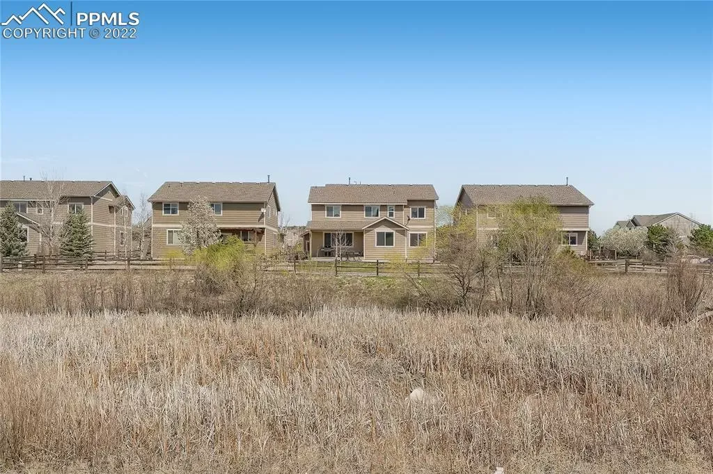A row of houses are sitting on top of a dry grass field.