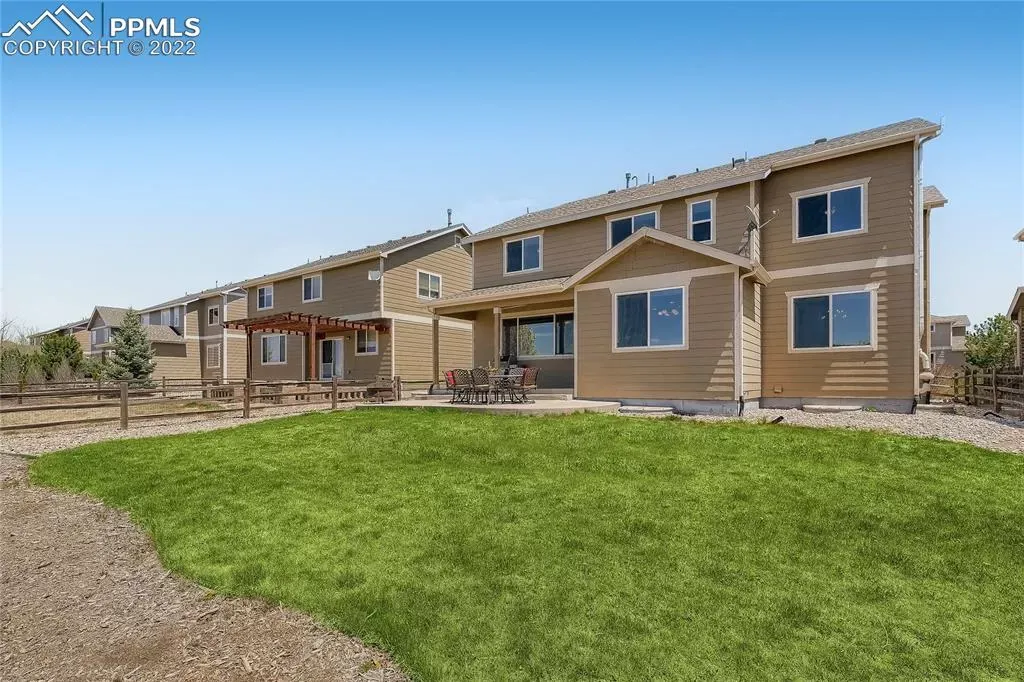 A row of houses with a large lawn in front of them.
