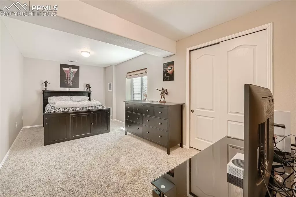 A bedroom with a bed , dresser , and television.