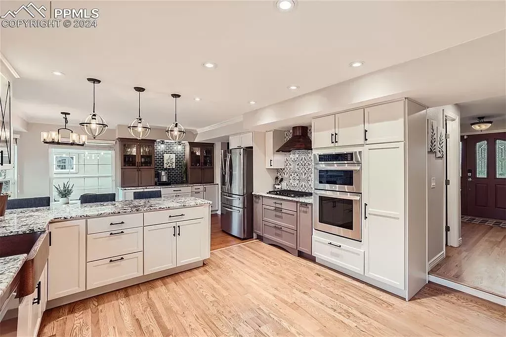 A large kitchen with white cabinets and stainless steel appliances.