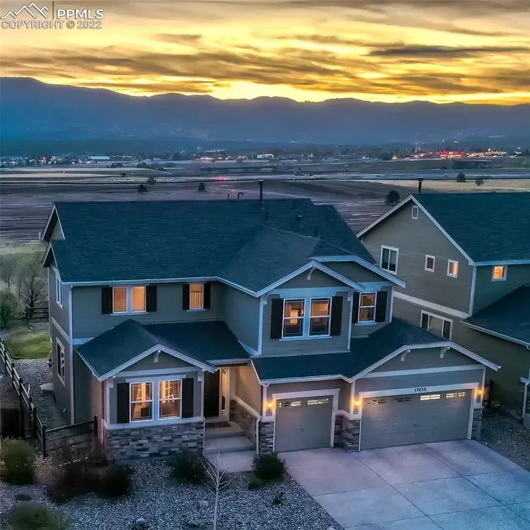 An aerial view of a house with a sunset in the background