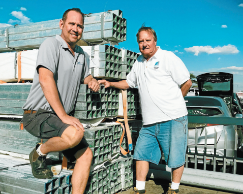 Two people standing at hot dipped post pipes