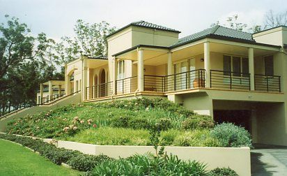 A large house is sitting on top of a grassy hill.